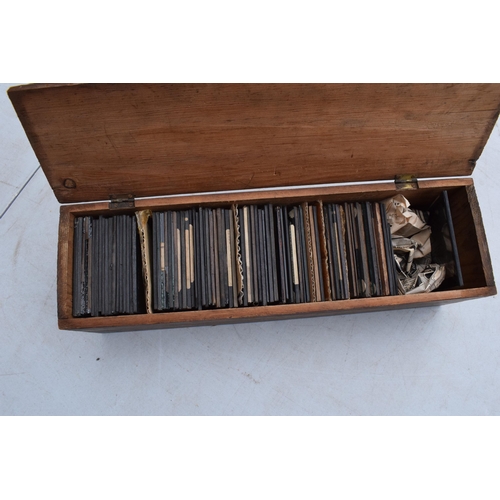 295 - A cased Negretti and Zambra magic lantern in wooden box with a box of slides with examples such as M... 