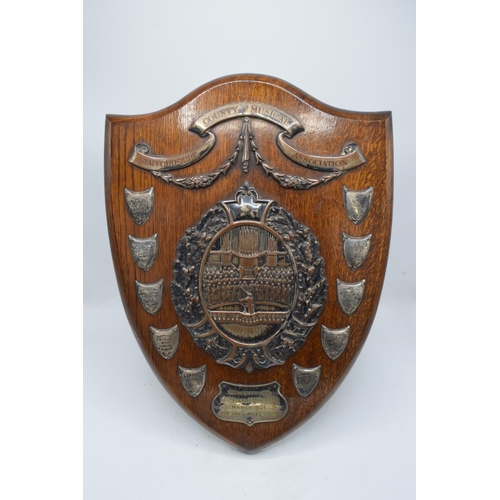 245 - A wooden presentation shield with hallmarked silver name shields and a silver plate central relief a... 