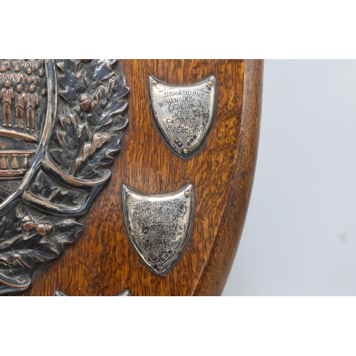 245 - A wooden presentation shield with hallmarked silver name shields and a silver plate central relief a... 