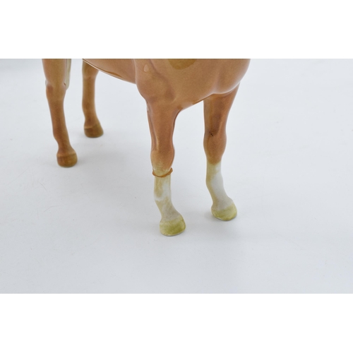 123 - A trio of Beswick horses to include brown hackney horse 1361, a palomino facing left and a grey foal... 