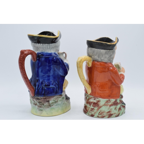 20 - A pair of late 19th century Staffordshire Toby jugs of similar form with each gent having crossed le... 