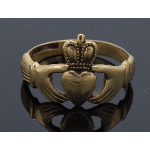 213 - 9ct gold ring with a heart wearing a crown held by hands, 2.9 grams. UK size R.