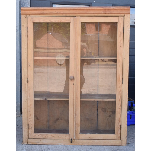 274 - An early 20th century tall pine display cabinet with glazed doors, 106x35x139cm tall.