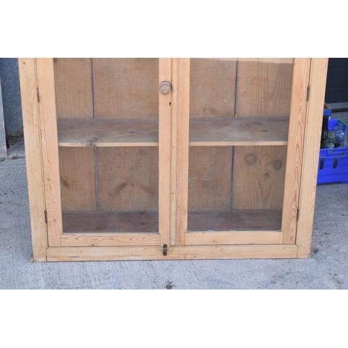 274 - An early 20th century tall pine display cabinet with glazed doors, 106x35x139cm tall.