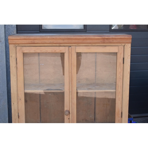 274 - An early 20th century tall pine display cabinet with glazed doors, 106x35x139cm tall.