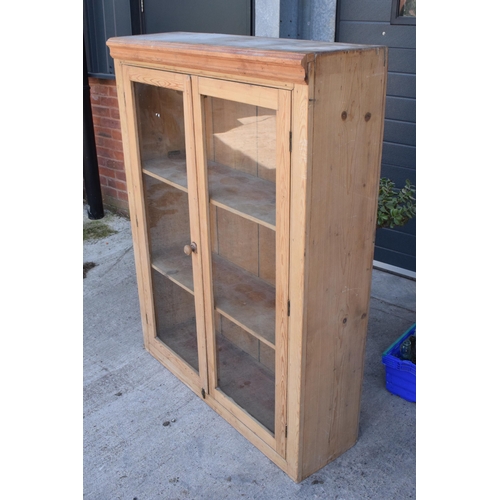 274 - An early 20th century tall pine display cabinet with glazed doors, 106x35x139cm tall.