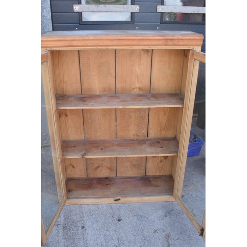 274 - An early 20th century tall pine display cabinet with glazed doors, 106x35x139cm tall.