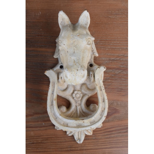 282 - A vintage 20th century painted white cast metal door knocker in the form of a horse's head, 18cm tal... 