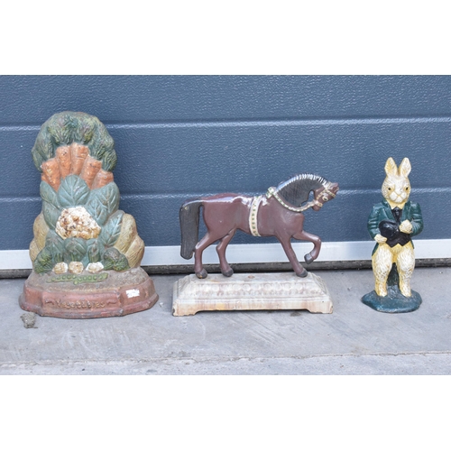 286 - A trio of painted cast metal door stops of varying forms (3).