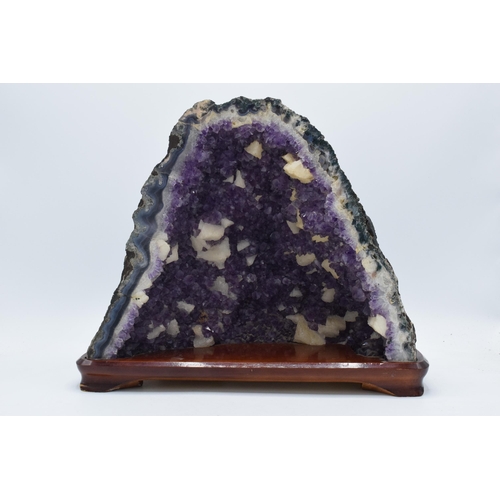 294 - A geological rock specimen of an amethyst geode, 38cm wide, 31cm tall.