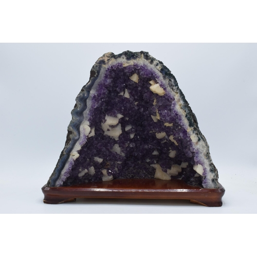 294 - A geological rock specimen of an amethyst geode, 38cm wide, 31cm tall.