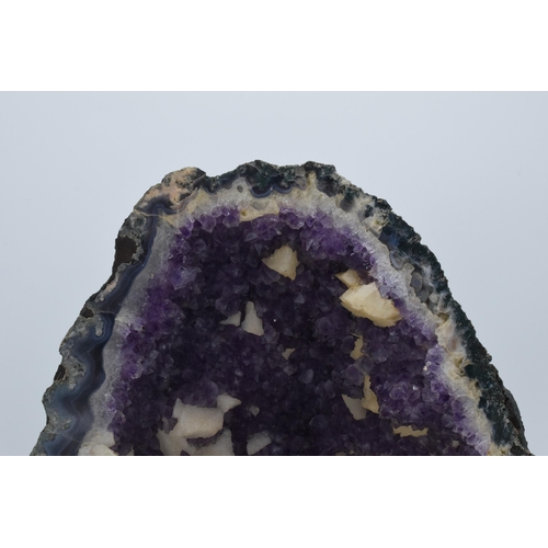 294 - A geological rock specimen of an amethyst geode, 38cm wide, 31cm tall.