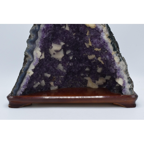 294 - A geological rock specimen of an amethyst geode, 38cm wide, 31cm tall.