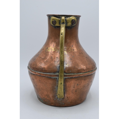 297 - 19th century copper and brass vessel / jug, 26cm tall.