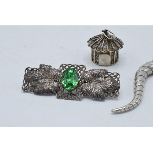 220Y - A silver filigree pendant in the form of a hut, a silver swirl pendant and a brooch set with a paste... 