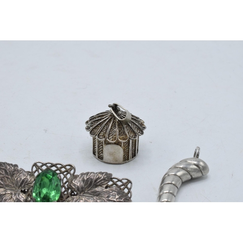 220Y - A silver filigree pendant in the form of a hut, a silver swirl pendant and a brooch set with a paste... 