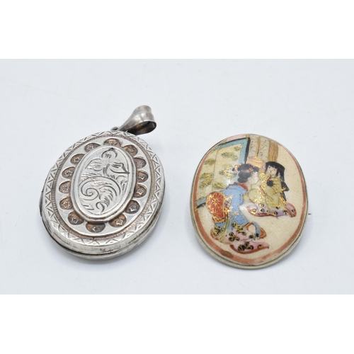 220Z - A silver locket together with a silver backed oriental scene brooch (2).