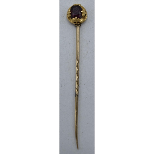 224 - 9ct gold (testing as 9ct gold or better) stick pin set with purple stone, 1.6 grams. 6cm long.