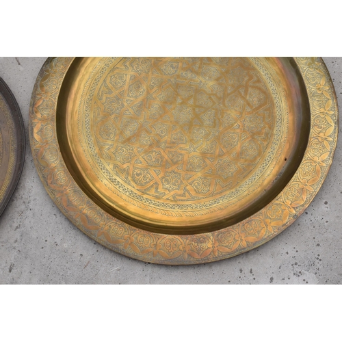 279A - A pair of 19th century brass chargers of Islamic / Middle Eastern design, largest 70cm diameter with... 