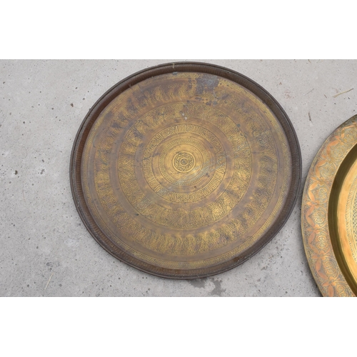 279A - A pair of 19th century brass chargers of Islamic / Middle Eastern design, largest 70cm diameter with... 