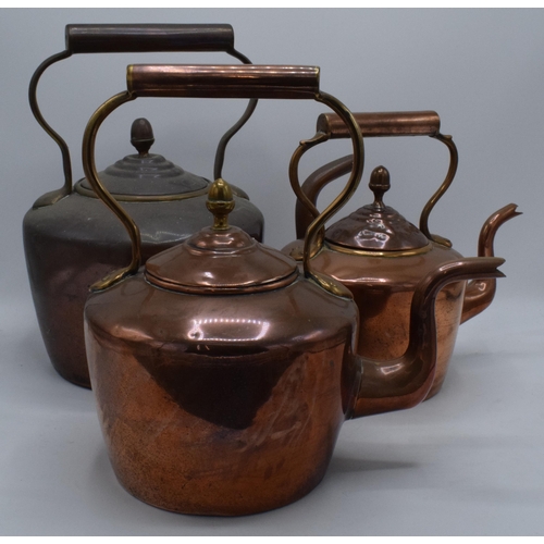 280 - A trio of Victorian brass and copper kettles with one having a hinged lid, tallest 32cm tall (3).