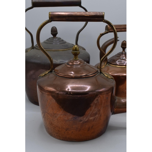 280 - A trio of Victorian brass and copper kettles with one having a hinged lid, tallest 32cm tall (3).