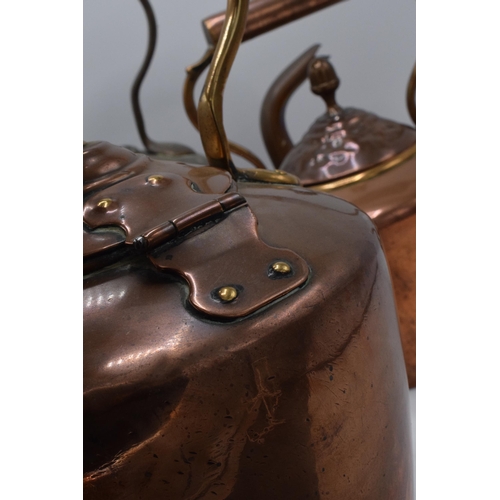 280 - A trio of Victorian brass and copper kettles with one having a hinged lid, tallest 32cm tall (3).