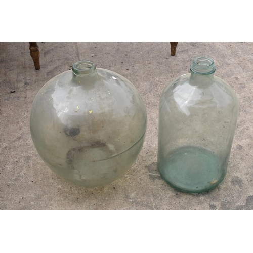 322 - A large globular glass jar together with one similar example, tallest 57cm.