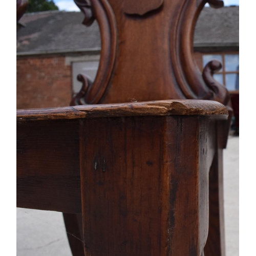 375 - A pair of Victorian oak carved shaped back hall chairs with raised shell motif (2), 86cm tall.