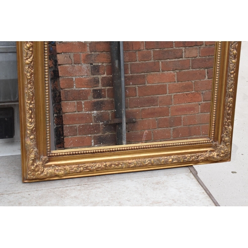 379 - A large vintage gilt-style hanging over mantle mirror, 118cm tall.