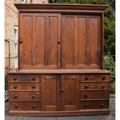 Large Victorian stained pine housekeepers cupboard with sliding doors to top half above a central cupboard flanked each side by 4 drawers, 213cm wide, 60cm deep, 230cm tall.