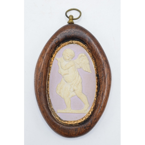 77 - A 19th century lilac jasperware oval cameo of a cherub with domed shaped with gilt floral edge in wo... 