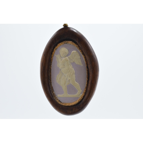 77 - A 19th century lilac jasperware oval cameo of a cherub with domed shaped with gilt floral edge in wo... 