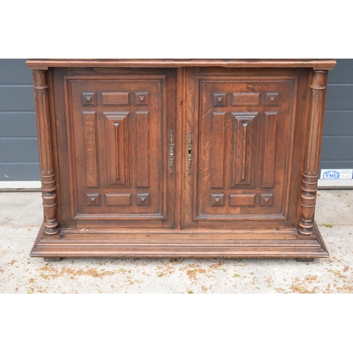 395A - An early 20th century wooden kitchen dresser with glazed upper doors and carved decoration. 218cm ta... 