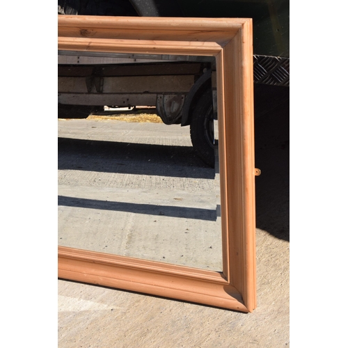 242 - A vintage 20th century pine wall hanging bevel-edged mirror, 96 x 77cm.