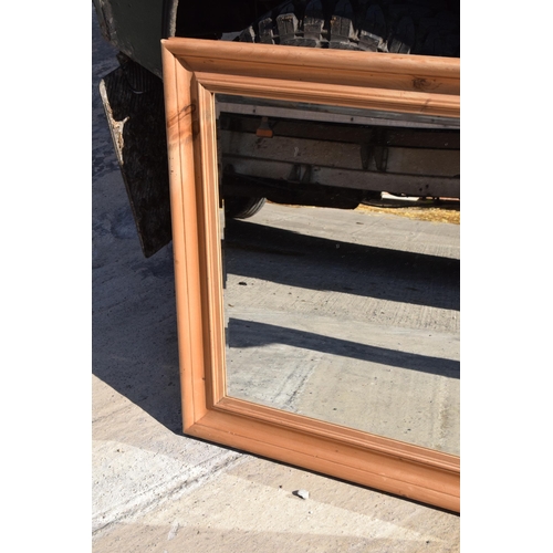 242 - A vintage 20th century pine wall hanging bevel-edged mirror, 96 x 77cm.