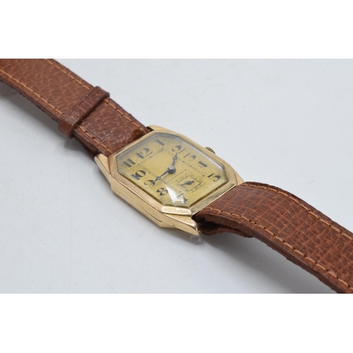 358 - 9ct gold gentleman's wristwatch on leather strap, 26mm wide. In ticking order.