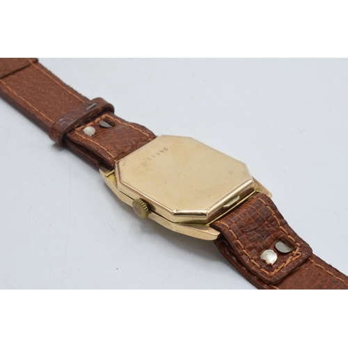 358 - 9ct gold gentleman's wristwatch on leather strap, 26mm wide. In ticking order.