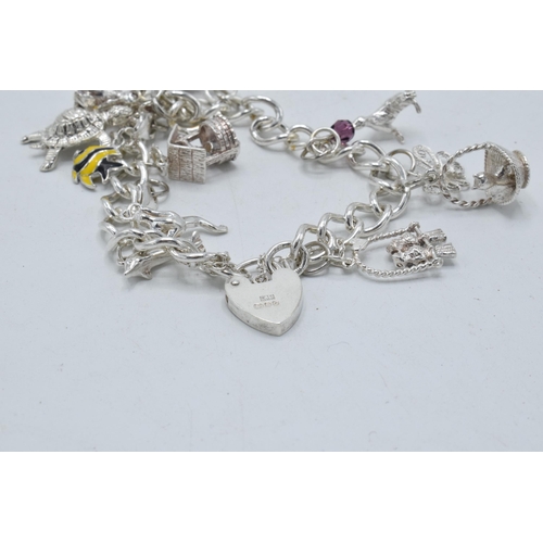 366 - Silver charm bracelet with array of charms to include basket, turtle and others, 36.7 grams.