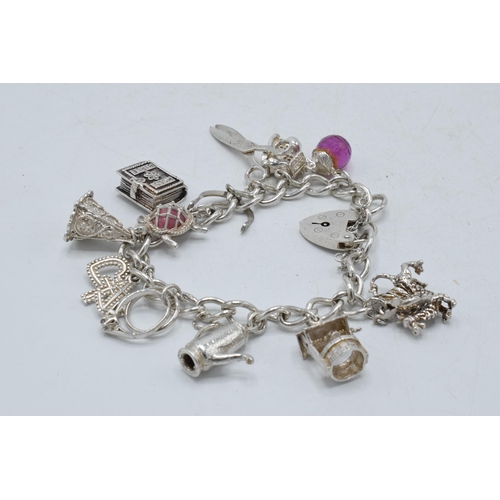 368 - Silver charm bracelet to include teapot, scissors and others, 49.1 grams.