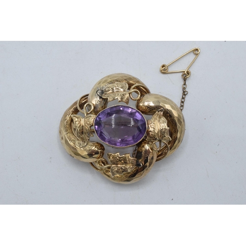 434 - Victorian gold amethyst brooch with raised floral decoration, 7.4 grams, 4cm wide.