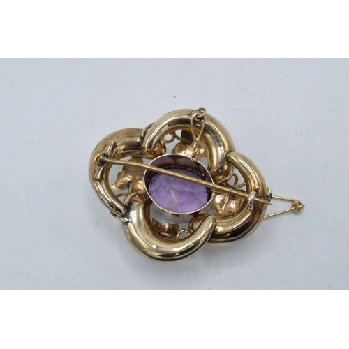 434 - Victorian gold amethyst brooch with raised floral decoration, 7.4 grams, 4cm wide.