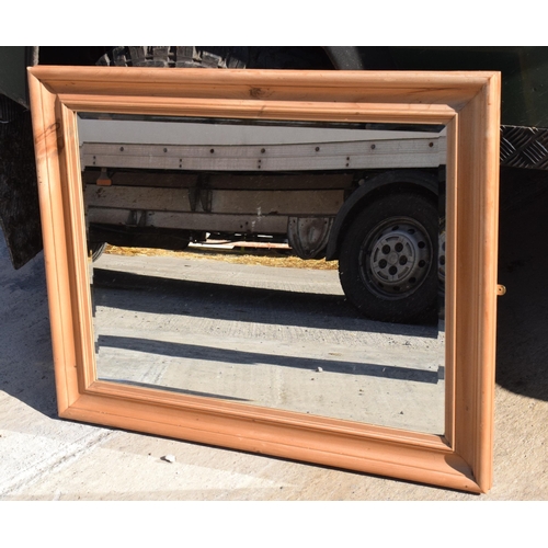 244 - A vintage 20th century pine wall hanging bevel-edged mirror, 96 x 77cm.