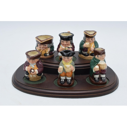 170 - Royal Doulton Tiny Tobies set of Toby jugs together with wooden stand, all matching number (7).