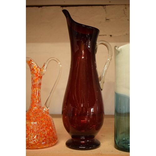 32 - A collection of assorted art / studio glass in the form of jugs (4), tallest 44cm.