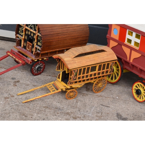 331 - A trio of wooden bow-top Romany caravan models, largest 42cm long.