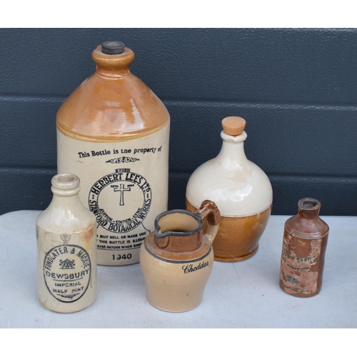 338 - A collection of stoneware bottles and flagons to include Herbert Lees, Findlater and Mackie together... 