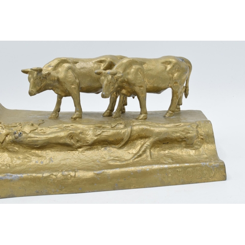 341 - A cast metal inkwell in the form of an mountainous cattle scene, 32cm long.