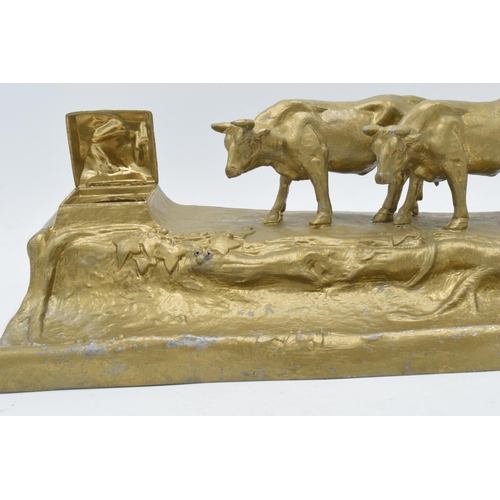 341 - A cast metal inkwell in the form of an mountainous cattle scene, 32cm long.