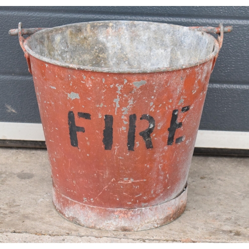 344 - Vintage metal riveted fire bucket with swing-over handle painted red with 'FIRE' in black, 31cm tall... 